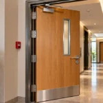 Closed timber fire door with a self-closing mechanism in a contemporary residential corridor.
